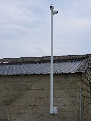 Caméra de surveillance extérieure installée sur un mât en toiture